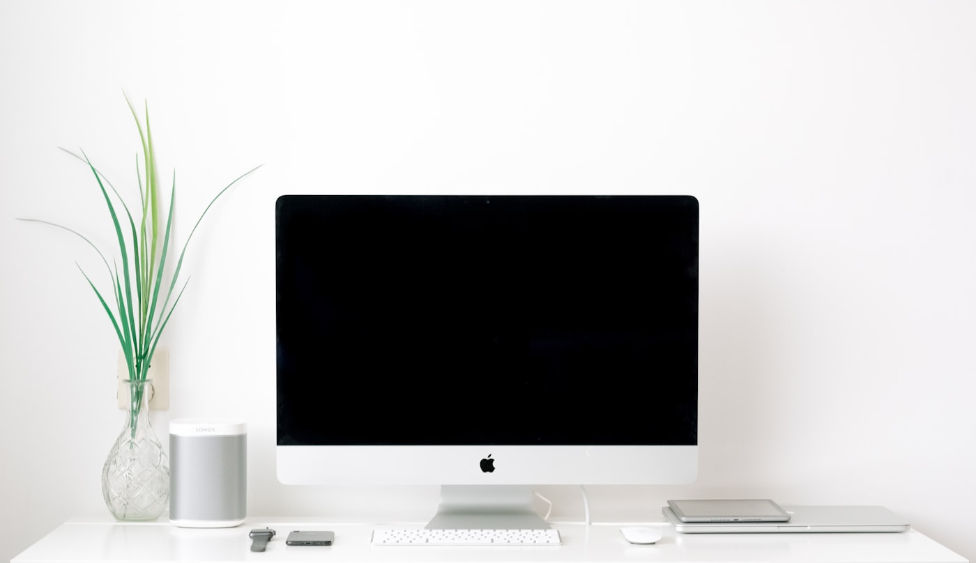A closed laptop with a charging cable plugged into its side