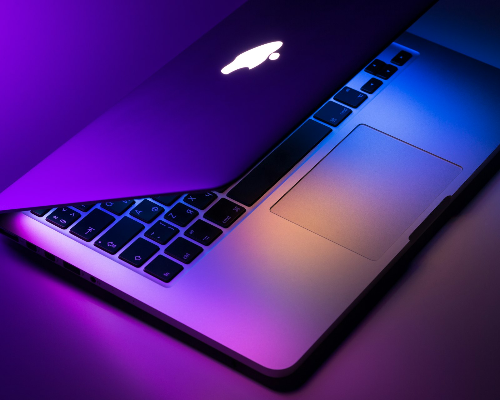 A laptop open on a tidy wooden desk in soft daylight
